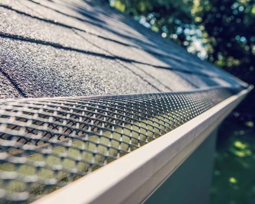 Metal mesh gutter guard installed on asphalt shingle roof
