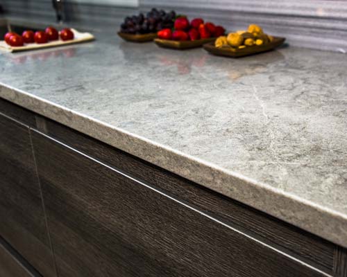 Gray stone countertop with dark wood cabinetry